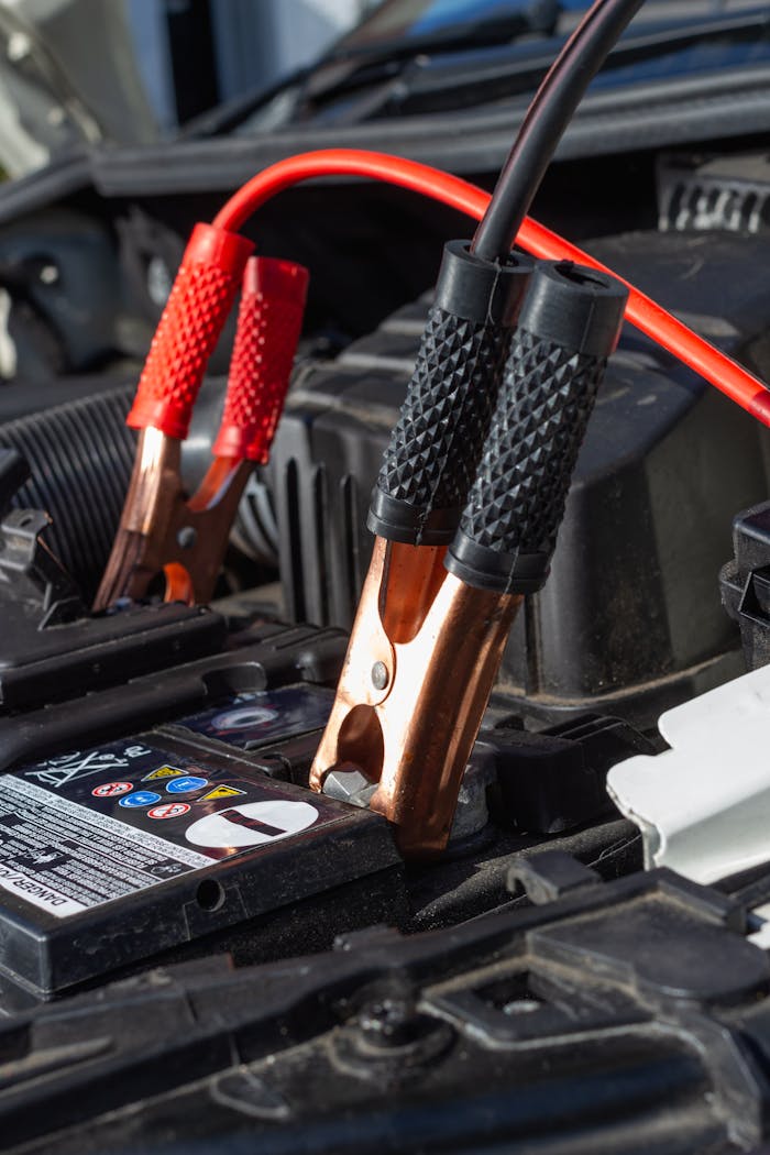 our-services-2 Close-up view of jumper cables charging a car battery.